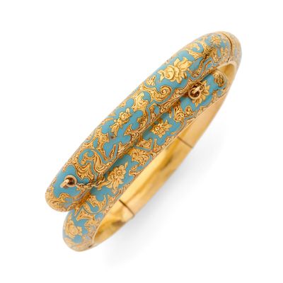 un gros plan d'un bracelet en or et turquoise sur fond blanc