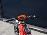 a red dirt bike parked in front of a garage door