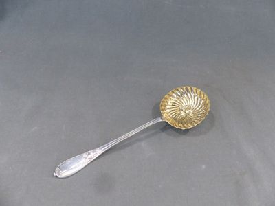 une cuillère en argent ornée d'une coquille en or