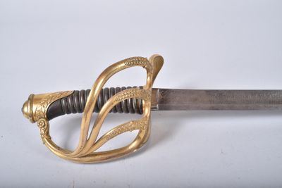 an image of a sword with a gold handle on a white surface