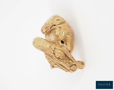 une sculpture en or représentant un oiseau perché sur une branche
