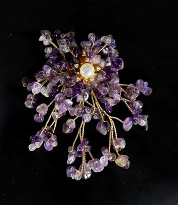 purple amethorate and pearl cluster broochle on a black background
