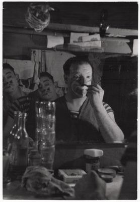 photographie en noir et blanc d'un homme assis à une table devant un miroir