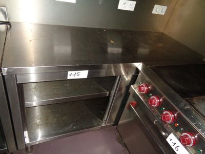 a stainless steel oven with three shelves in the middle of the room