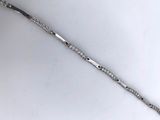 a silver bracelet that has a long silver chain on it