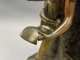une statue en bronze représentant une femme tenant un bol