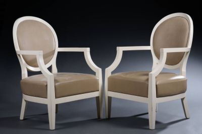 pair of white chairs with beige upholstered cushions against a black background