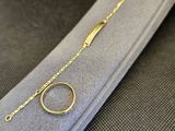 un gros plan d'un bracelet en or sur lequel est enfilée une bague