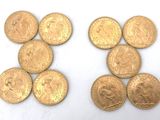 several gold coins are arranged in a row on a white surface