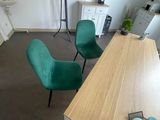 deux chaises vertes et une table en bois dans une pièce