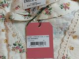 une photo d'une chemise blanche avec une étiquette rose dessus