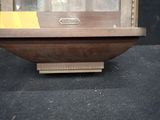 a wooden display case with a clock inside of it