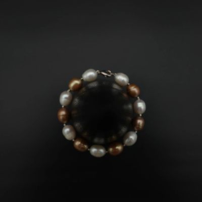 un gros plan d'un bracelet orné de perles sur un fond noir