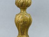a close up of a gold candle holder on a table