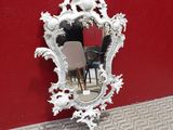 un miroir accroché au mur, à côté d'une chaise et d'une table