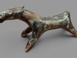 sculpture of a horse made of clay on a gray surface