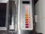 a silver microwave with a digital display on it