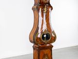 a wooden grandfather clock that is standing in a room