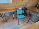several chairs and a table in a room with wooden floors