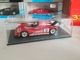 a red toy car in a display case on a table