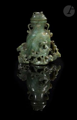 une image représentant une figurine en jade vert posée sur une surface noire