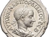 a silver coin with an image of a man wearing a headdress
