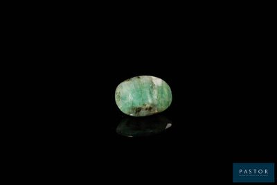 a close up of a green stone on a black surface