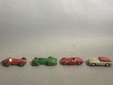 several toy cars are lined up in a row on a gray surface