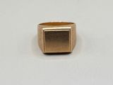a close up of a gold ring on a white surface