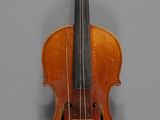 un vieux violon posé sur une table près d'un mur