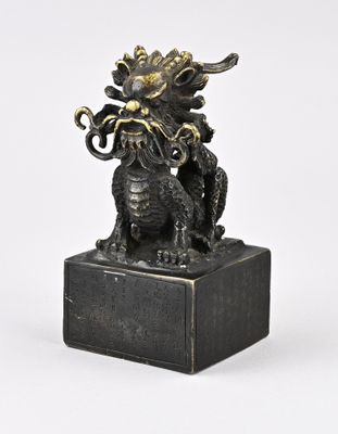 une photo d'une statue en bronze représentant un dragon posée sur un socle