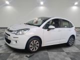 la petite voiture blanche est garée sur un carrelage à carreaux