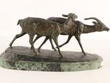 bronze sculpture of two goats on a marble base on a white background