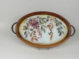 a tray with flowers and leaves on it on a stand