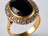 Gros plan sur une bague en or ornée d'une pierre noire