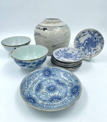 plusieurs assiettes et bols bleus et blancs posés sur une surface blanche