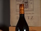 a bottle of wine sitting on a table next to a box of wine