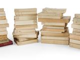 plusieurs piles de livres empilées les unes sur les autres sur une surface blanche