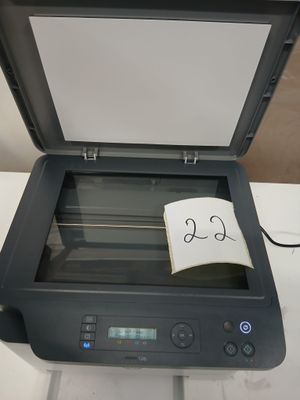 une imprimante sur laquelle est posée une note, posée sur une table