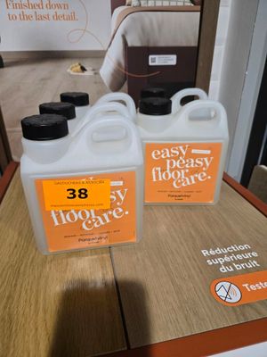 deux gallons de produit d'entretien facile pour sols posés sur une table devant une affiche