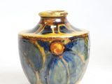 a blue and yellow vase sitting on a white surface