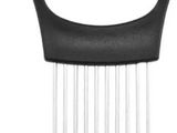 a close up of a black and silver comb with a dog in the background