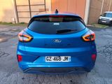 the rear end of a blue car parked in a parking lot