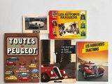 plusieurs livres posés sur une table blanche, avec une voiture rouge et une voiture rouge
