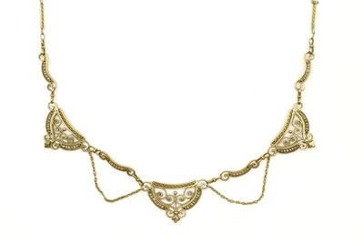 gros plan d'un collier en or sur fond blanc