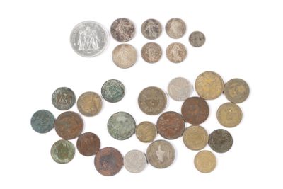 quelques pièces et un penny posés sur une surface blanche, avec une pièce en arrière-plan