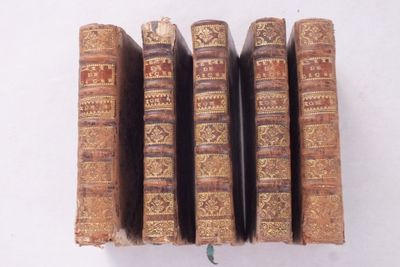 plusieurs vieux livres sont empilés sur une surface blanche