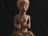 l'image d'une statue de femme assise au sommet d'un rocher