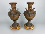 paire de vases anciens en bronze reposant sur des socles en bois, sur fond blanc