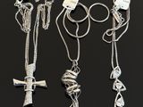three silver necklaces with a cross and a knot on a chain